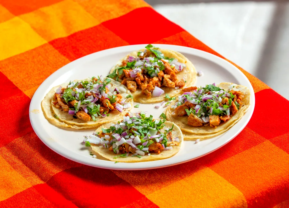 Grilled chicken street tacos with onions, cilantro and cheese