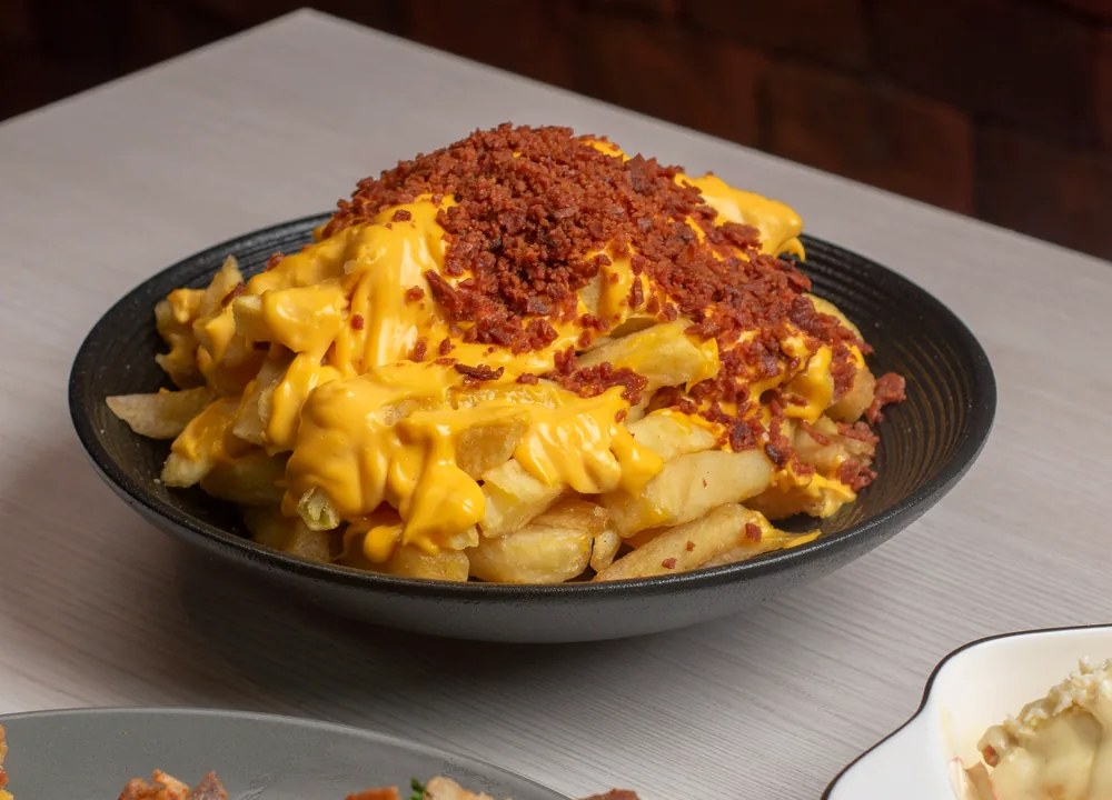 Seasoned loaded fries topped with cheese sauce, bacon and chives