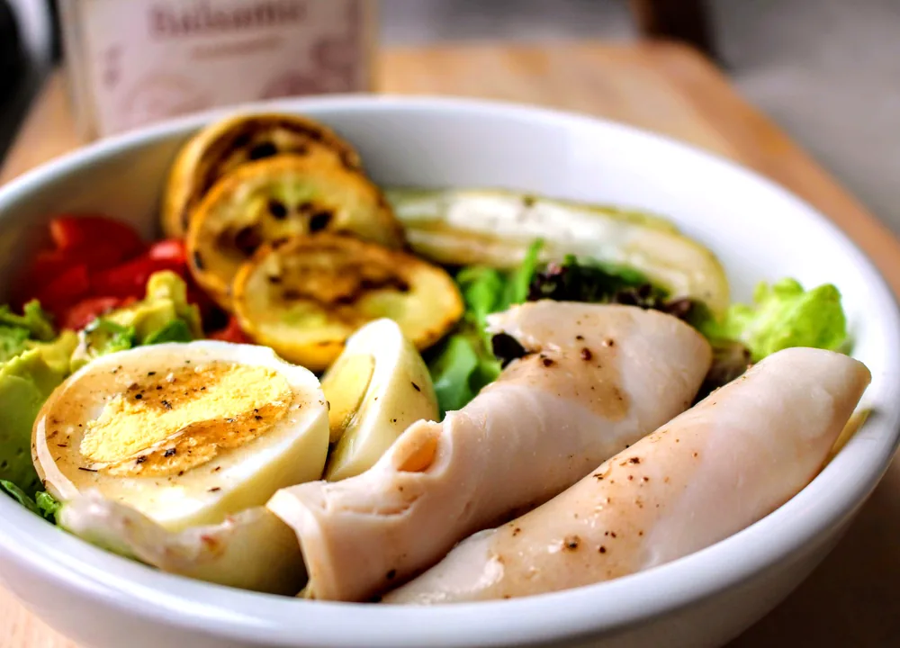 Chef salad with greens, turkey, ham, hard-boiled egg, cheddar and tomatoes